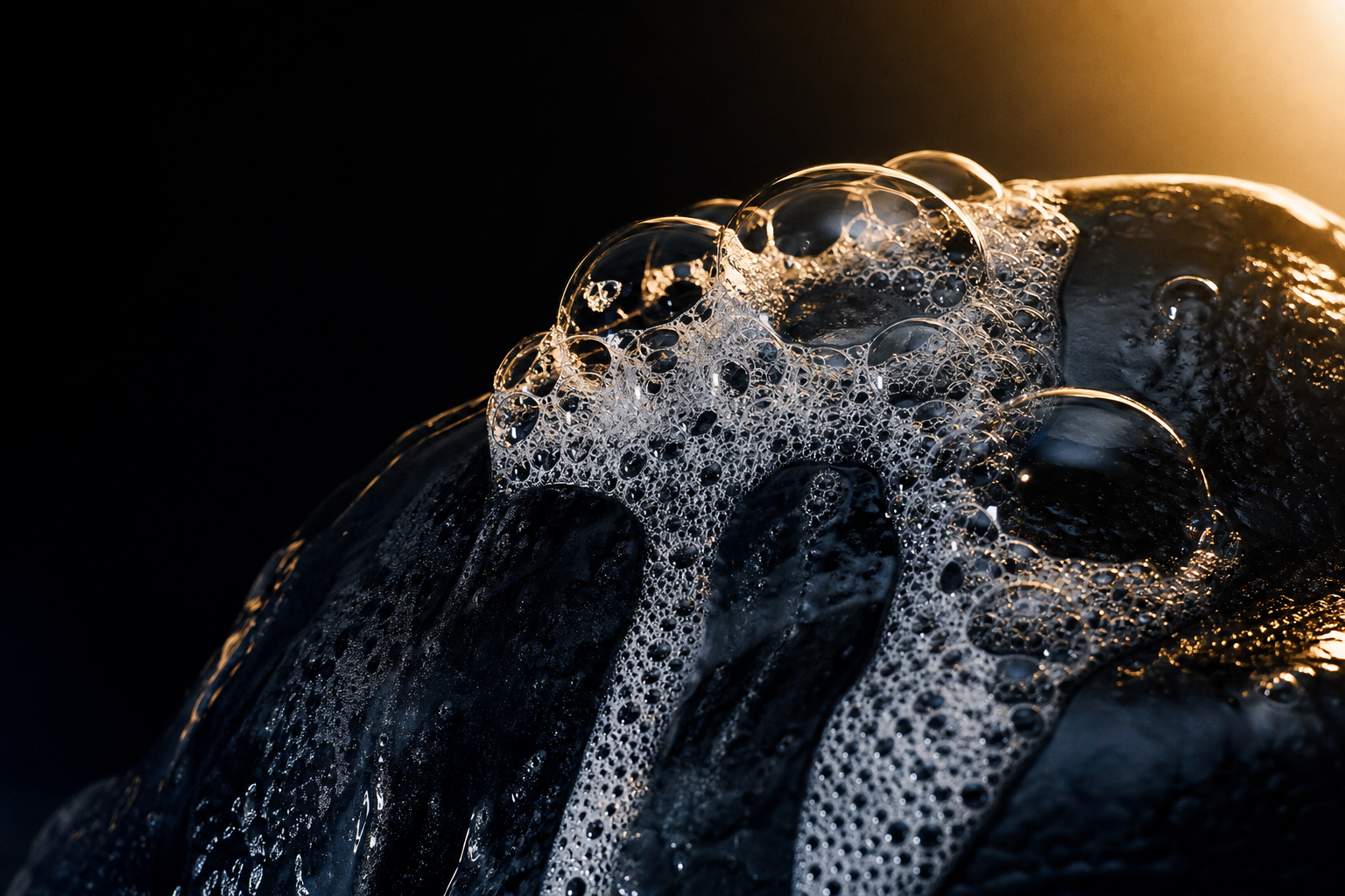 Backlit soap bubbles on dark surface — soapy massage Bangkok